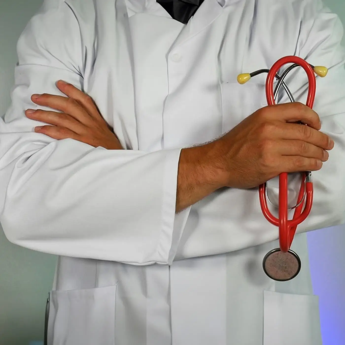 A doctor in a white coat holding a stethoscope, representing specialist clinical assessment